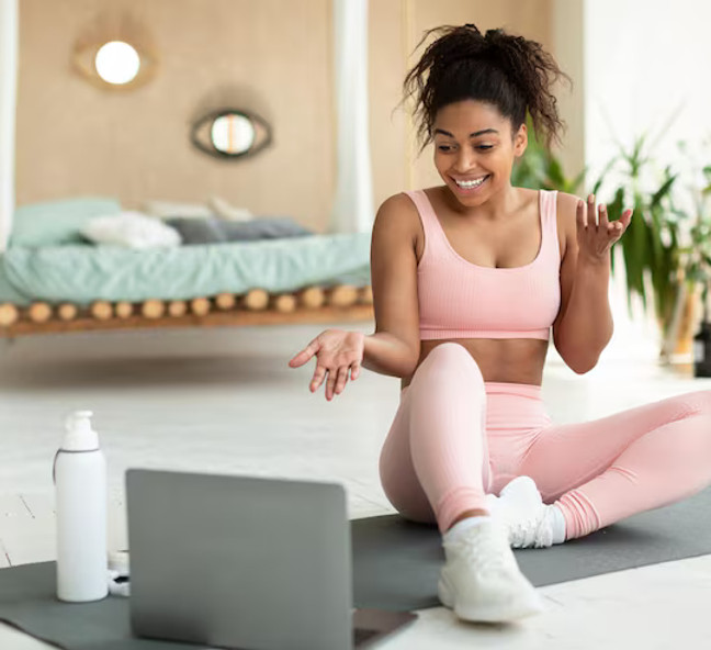 Client doing an exercise session at home guided by an online coach Client doing an exercise session at home guided by an online coach